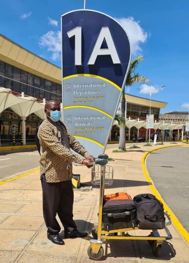 Kenianer mit Gepäcktrolley am Flughafen