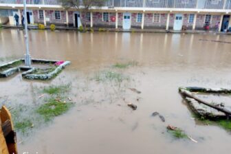 Überschwemmter Platz zwischen den Gebäuden von Tumaini