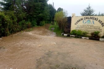Überflutete Strasse vor dem Tor des Waisenhauses Tumaini