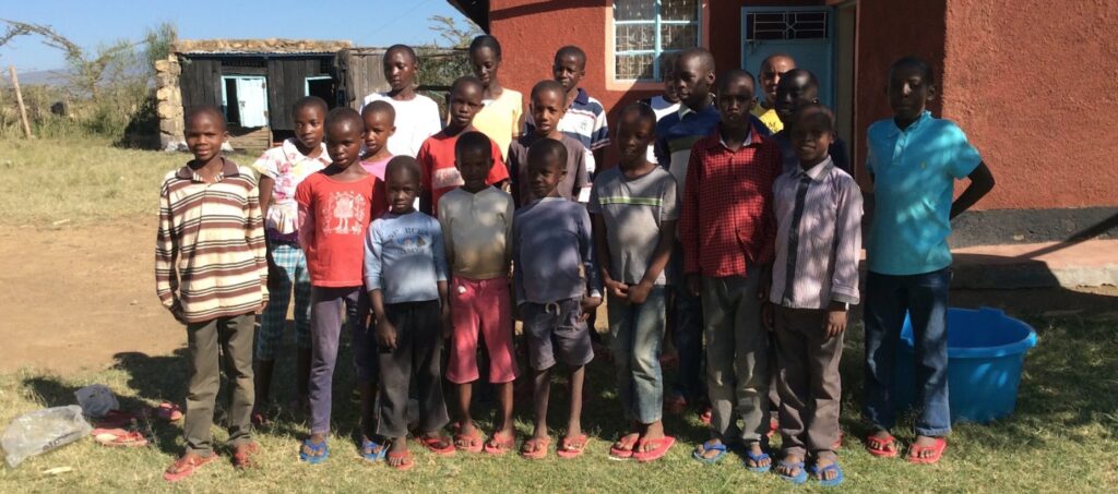 20 Kinder stehen vor dem Waisenhaus Beat the Drum