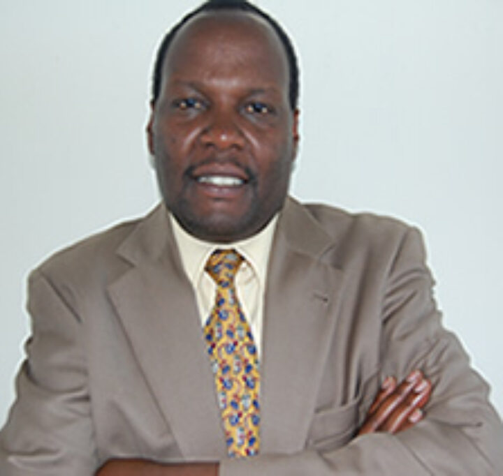 Kenianischer Mann in grauem Anzug mit gelb-gemusterter Krawatte