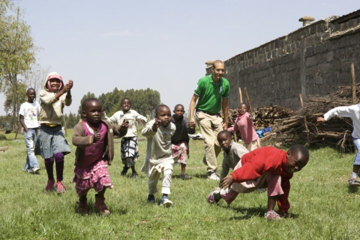10 rennende kenianische Kinder, dazwischen ein Schweizer Volontär